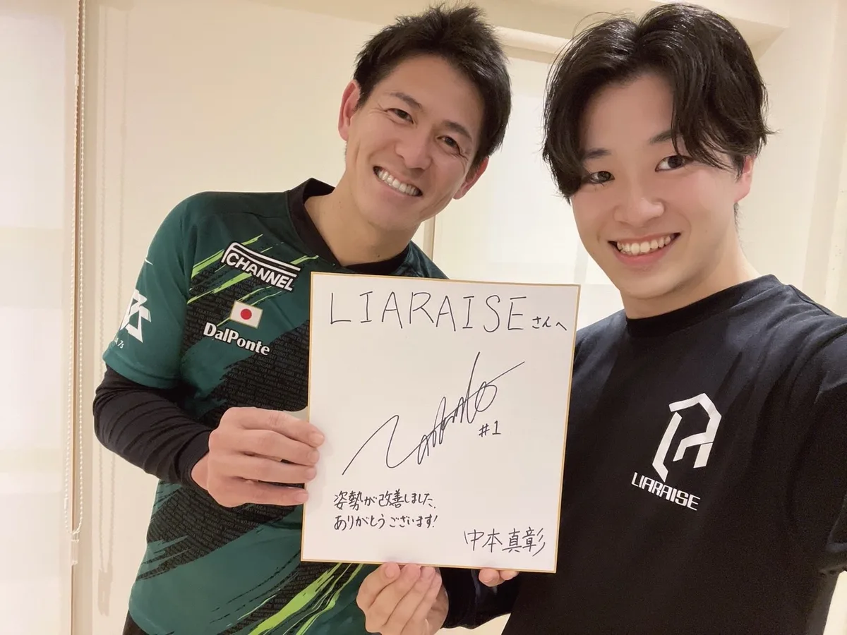 「姿勢が改善しました。ありがとうございます!」と書かれたサイン色紙を持つ中本真彰選手と野田